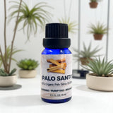 Bottle of Palo Santo oil blend with plants in the background