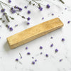 Palo Santo Single Stick on a marble surface with scattered lavender flowers