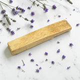 Palo Santo Single Stick on a marble surface with scattered lavender flowers