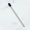 A replacement pen refill with a long metallic silver body and a black textured cap, placed diagonally on a white marble-patterned background.