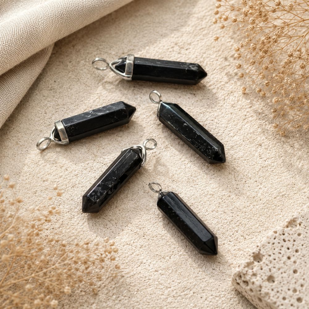 Man wearing a Shungite point pendant on a silver chain with a white linen shirt.