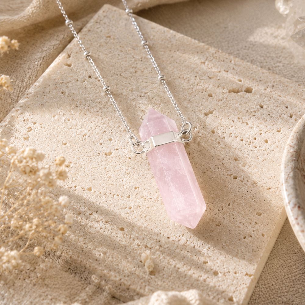 Rose quartz point pendant necklace on a silver-plated chain.