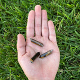 Tiger's Eye point pendants displayed on an open hand.