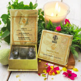 Crystal healing collection with packaging and crystals on a wooden surface with flowers and a candle.