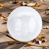 Round white selenite sphere on a wooden surface with leaves