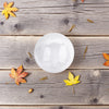 White mini selenite sphere on a wooden surface with autumn leaves