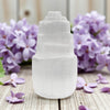 Selenite mini tower with purple flowers in background