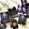 Tarot cards from 'The Secret Language of Darkness' by Denise Jarvis on a light surface with flowers.