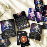 Tarot cards from 'The Secret Language of Darkness' by Denise Jarvis on a light surface with flowers.