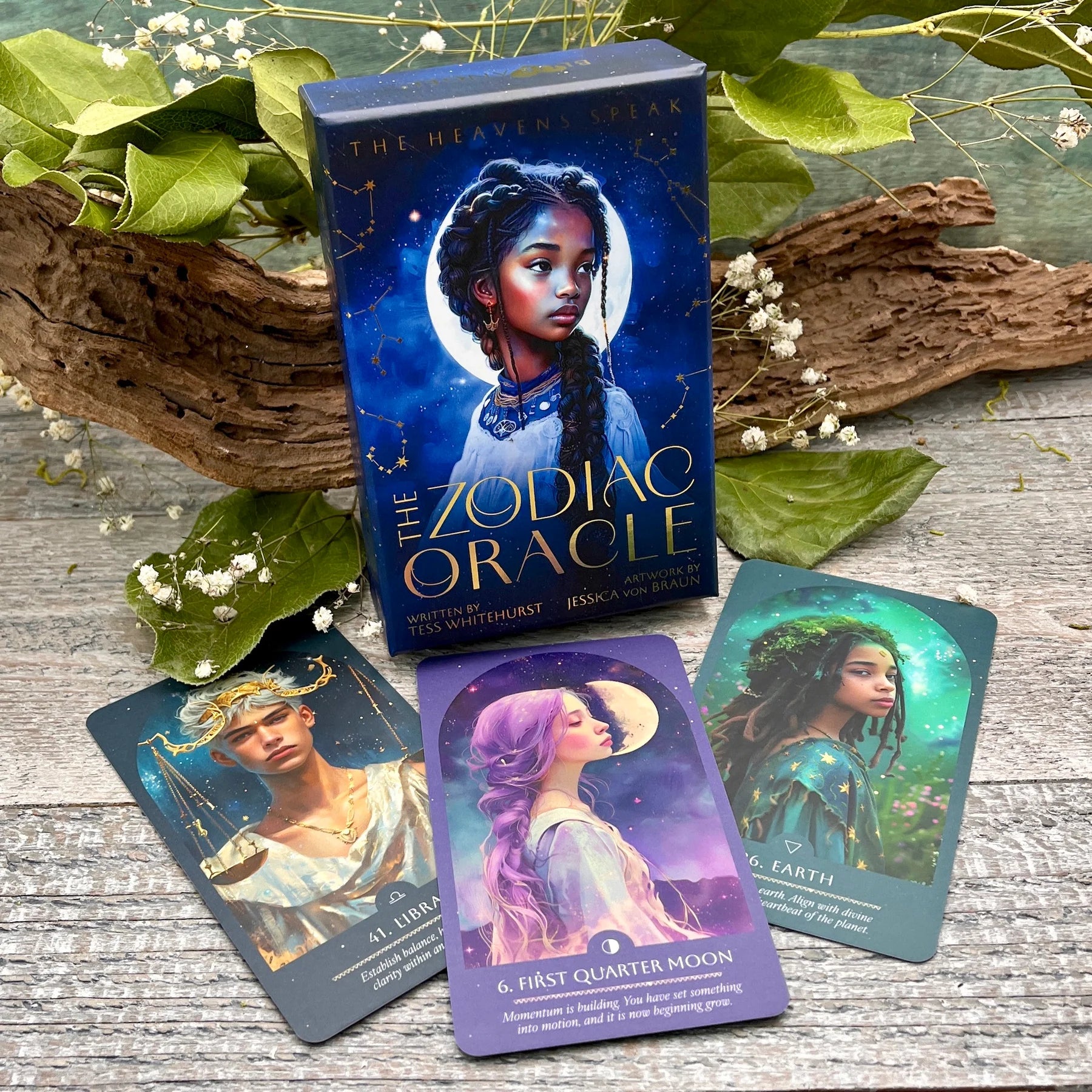 Zodiac Oracle cards with a box on a wooden surface with leaves and flowers.