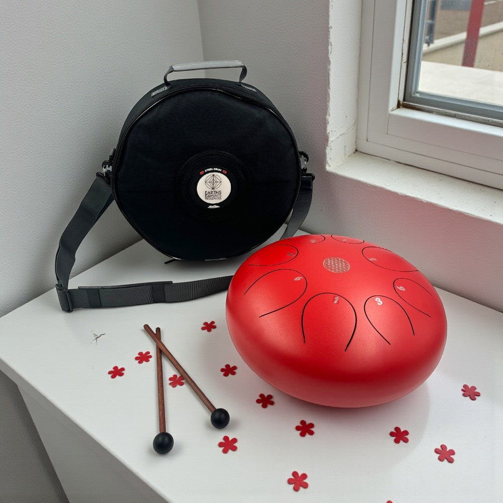 Red Steel Tongue Drum - 10" on a white surface near a window