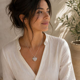 Person wearing a Tourmalinated Quartz mini heart pendant on a silver chain.