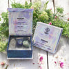 Crystal stone pack with packaging labeled 'Wisdom' on a wooden surface with plants in the background.