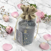 Candle in a decorative bag with pink flowers on a marble surface