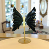 Butterfly sculpture — black obsidian —on a stand in a room with blurred background