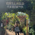 Woman walking through a garden entrance with 'Idyllwild Gardens' sign