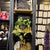 Shelf with various items including a statue, plants, and jewelry boxes.