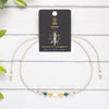 Necklace with Scorpio zodiac card on a white wooden background